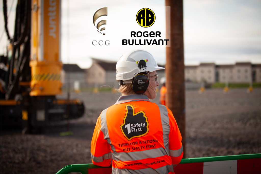 Woman in branded safety top looking at piling rig